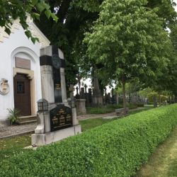 Durch eine lange Hecke sind die Gräber der bis 1946 verstorbenen Deutschen von den Gräbern der neu Angesiedelten abgetrennt