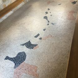 Das Mosaik stellt den See dar. Die schwarzen Steine stehen für überbaggerte Ansiedlungen, die roten für neu geschaffene